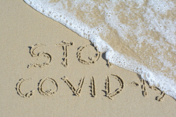 Stop covid-19 word on sand at samui island in Thailand on travel and medical concept