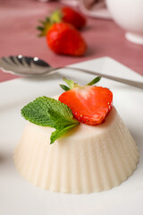 Plate with delicious strawberry panna cotta on table, closeup