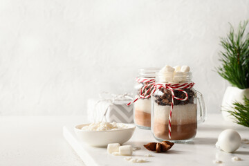 Edible Christmas gift in mason jar for making tasty chocolate beverage on white background. Festive holiday Xmas food. Copy space.