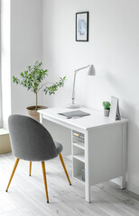Comfortable workplace with lamp, notebook and calendar on table near white wall