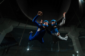 A man and a woman enjoy flying together in a wind tunnel. Free fall simulator