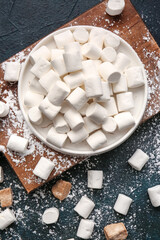 Plate with tasty marshmallows on dark background