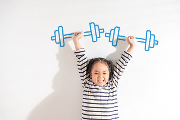 Funny Positive strong Asian little toddler kid girl lifting weight against the textured white...