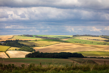 Patches of afternoon sunlight hitting the farmland of the south downs from Newmarket hill near...