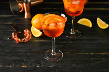 Glasses of tasty aperol spritz cocktail on dark wooden background