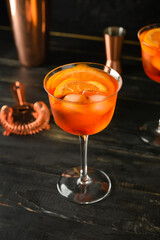 Glass of tasty aperol spritz cocktail on dark wooden background