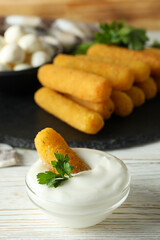 Concept of tasty food with cheese sticks on white wooden table