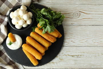 Concept of tasty food with cheese sticks on white wooden table