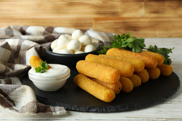 Concept of tasty food with cheese sticks on white wooden table