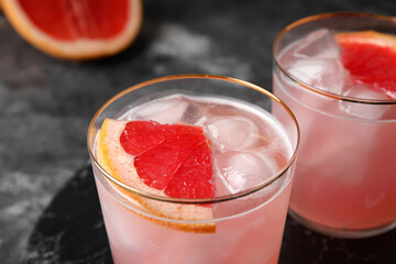 Glasses of tasty grapefruit margarita on grunge background, closeup