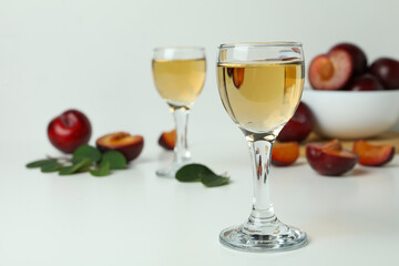 Plum vodka shots and ingredients on white background