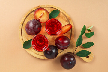 Plum brandy shots and ingredients on beige background