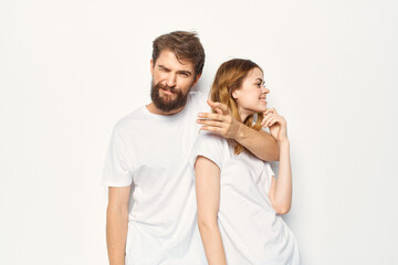 Cheerful man and woman in white t-shirts studio fun posing