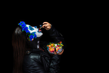 Halloween Catrina Zombie Eating colored sweets. Halloween costume and makeup.