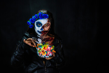 Halloween Catrina Zombie Eating colored sweets. Halloween costume and makeup.