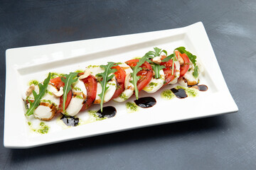 Caprese in a plate. Mozzarella, tomatoes and arugula.