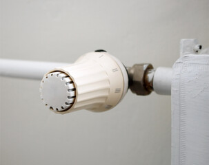 Heat prices and energy crisis concept. Temperature knob of heating radiator, thermostat, reduce heating costs.