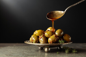 Spicy green olives are poured with olive oil with spices.