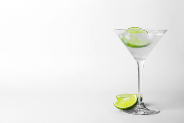 Glass of tasty gin and tonic on light background
