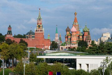Cityscape of Moscow city downtown district. Moscow Kremlin with Spasskaya Tower and St. Basil's Cathedral rises above Zaryadye park. Russian architecture theme.