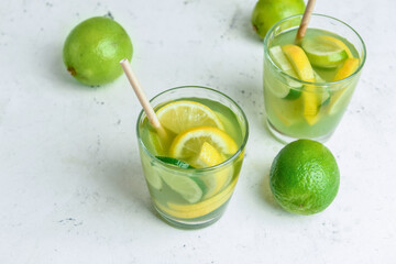 Glasses with tasty green lemonade on light background