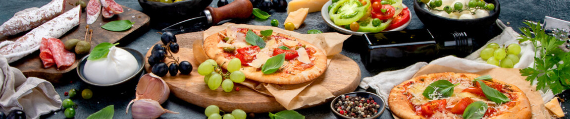 Italian food assortment on dark background.