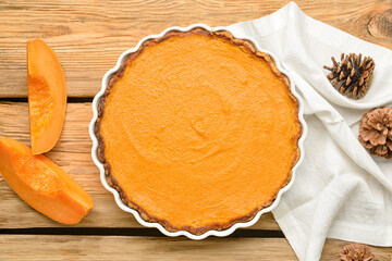 Baking dish with tasty pumpkin pie on wooden background