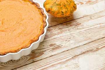 Baking dish with tasty pumpkin pie on white wooden background, closeup