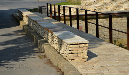 stone marl walls with stone cladding by the pool, ponds, fire tanks. metal bike racks and trash...