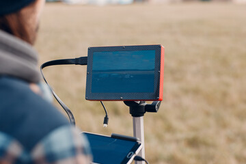 Man pilot controlling quadcopter drone with remote controller screen display