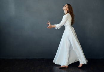 Fototapeta na wymiar woman in full length dress posing dance dark background