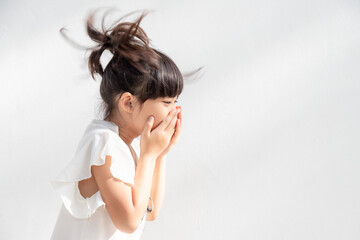 Asian child girl sick with sneezing on the nose and cold cough on tissue paper because weak or virus and bacteria from dust weather