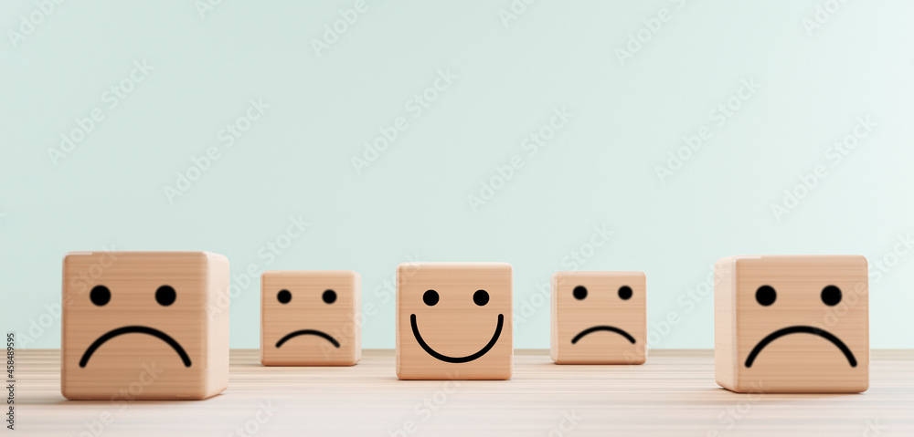Poster Smile face print screen on wooden cube block among sadness face for customer service evaluation and emotion mindset concept by 3d render.