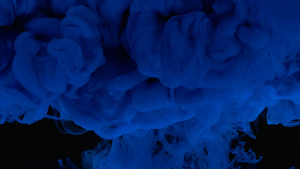Blue cloud of ink. Cosmic magic background. Waves and drops of blue paint. Beautiful abstract background.