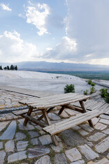 Rural wooden picnic table bench on green grass hill in Hierapolis Pamukkale mountain landscape