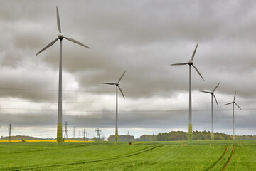 wind power generators in a green gras field in cloudy weather