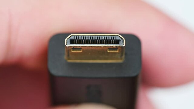 Close up of HDMI display monitor connector system or connection interface in hand isolated on white background. Display transfer information for digital camera gadget smartphone or laptop.
