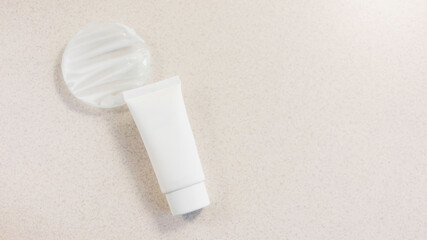 tube with face, body or hand cream on a white background with the texture of the cream on a laboratory glass. Copy space, mock up