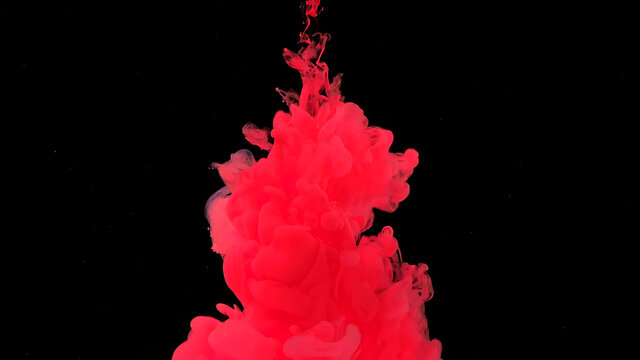 Waves and drops of scarlet colors. Beautiful abstract background. Amazing space magic background. Scarlet watercolor ink in water on a black background.