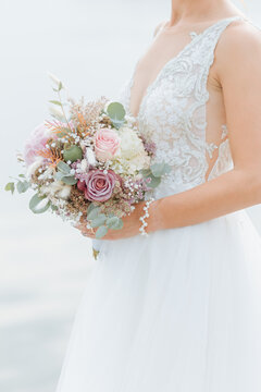 beautiful bride in white wedding dress holds a beautiful bridal bouquet with blue hydrangea in her hand. Boho wedding 