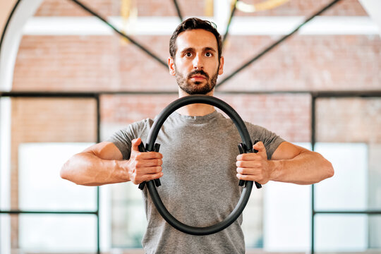 Fit athletic man using a pilates Magic Circle or ring