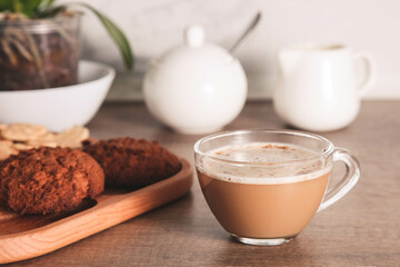 Coffee with milk in a glass cup with cookies