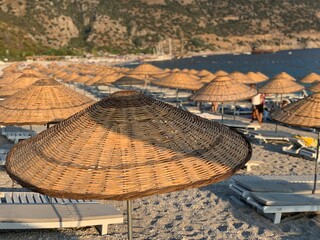 Beach vacation on the sandy seashore. Sea beach with umbrellas and sun loungers. Summer vacation on the Mediterranean.