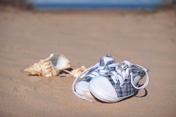 Cute baby small shoes in sunny beach.Selective focus