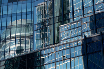 Naklejka na ściany i meble Glass buildings, skyscrapers in mirror blue abstract reflections