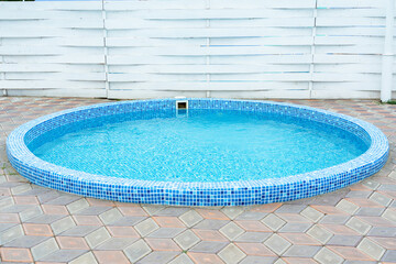 Fototapeta na wymiar Round pool with blue water in the backyard