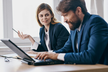 Obraz premium colleagues sitting at a desk with a laptop communication professionals