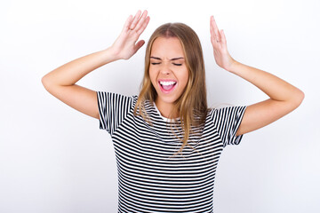 beautiful blonde girl wearing striped t-shirt on white background goes crazy as head goes around feels stressed because of horrible situation