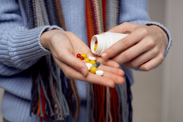 red-haired woman neck scarf pills in hand isolated background