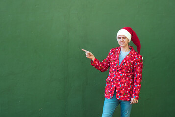 Studio photo of a man pointing to a side in a christmas costume